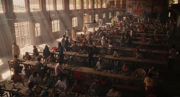 Movie still from “Eat Pray Love” (2010), directed by Ryan Murphy – Many people are sitting at long wooden tables in a large room; Extreme Wide shot, High angle