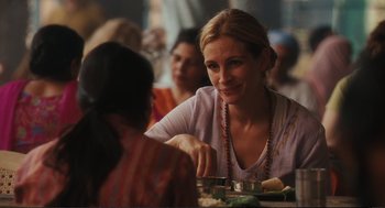 Movie still from “Eat Pray Love” (2010), directed by Ryan Murphy – A woman sitting at a table with a plate of food in front of her; Close Up shot, Over the shoulder angle