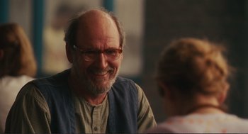 Movie still from “Eat Pray Love” (2010), directed by Ryan Murphy – An older man wearing glasses and a blue vest; Close Up shot, Over the shoulder angle