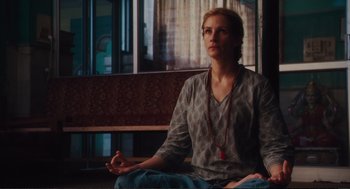 Movie still from “Eat Pray Love” (2010), directed by Ryan Murphy – A woman sitting on the ground with her eyes closed; Medium shot, Low angle