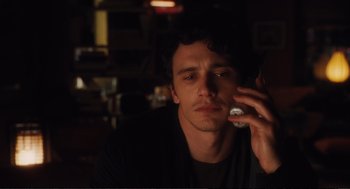 Movie still from “Eat Pray Love” (2010), directed by Ryan Murphy – A man sitting in the dark talking on a cell phone; Close Up shot, Over the shoulder angle