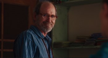 Movie still from “Eat Pray Love” (2010), directed by Ryan Murphy – An older man wearing glasses and a blue striped shirt; Close Up shot, Over the shoulder angle