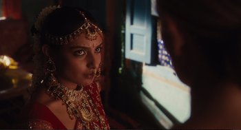 Movie still from “Eat Pray Love” (2010), directed by Ryan Murphy – A woman in a red and gold dress and a man in a red and gold suit; Close Up shot, Over the shoulder angle