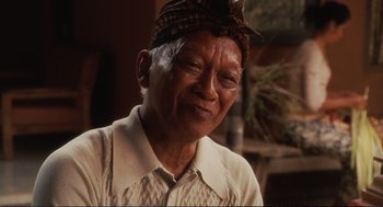 Movie still from “Eat Pray Love” (2010), directed by Ryan Murphy – An older man wearing a head scarf is smiling for the camera; Close Up shot, Low angle