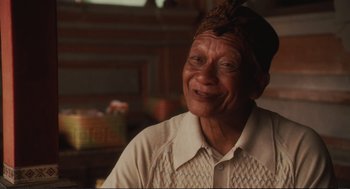 Movie still from “Eat Pray Love” (2010), directed by Ryan Murphy – An older man smiling for the camera in a room; Close Up shot, Low angle