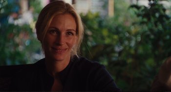 Movie still from “Eat Pray Love” (2010), directed by Ryan Murphy – A person smiling for the camera; Close Up shot, Over the shoulder angle