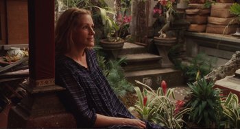 Movie still from “Eat Pray Love” (2010), directed by Ryan Murphy – A woman sitting on a bench next to some flowers; Medium shot, Over the shoulder angle