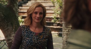 Movie still from “Eat Pray Love” (2010), directed by Ryan Murphy – A woman with blonde hair wearing a floral dress; Medium shot, Over the shoulder angle