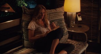 Movie still from “Eat Pray Love” (2010), directed by Ryan Murphy – A woman sitting on top of a couch reading a book; Medium shot, High angle