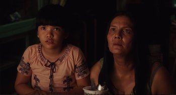 Movie still from “Eat Pray Love” (2010), directed by Ryan Murphy – A woman sitting next to a young girl in front of a candle; Close Up shot, Over the shoulder angle