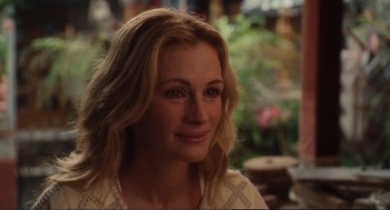 Movie still from “Eat Pray Love” (2010), directed by Ryan Murphy – A beautiful woman with blonde hair smiling for the camera; Close Up shot, Over the shoulder angle