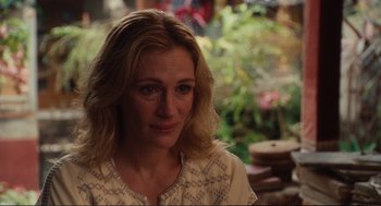Movie still from “Eat Pray Love” (2010), directed by Ryan Murphy – A person sitting in front of a plant; Close Up shot, Over the shoulder angle