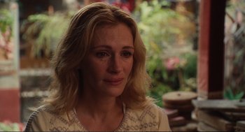 Movie still from “Eat Pray Love” (2010), directed by Ryan Murphy – A person sitting in front of a plant; Close Up shot, Over the shoulder angle