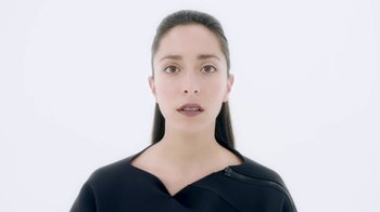 Movie still from “Black Mirror” (2011), created by Charlie Brooker – A young woman with long black hair wearing a black top; Close Up shot, Low angle