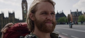Movie still from “Black Mirror” (2011), created by Charlie Brooker – A person with long hair and a beard; Close Up shot, Low angle