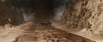 Movie still from “Fast & Furious” (2009), directed by Justin Lin – A car driving down a street with a mountain in the background; Extreme Wide shot, High angle