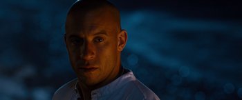 Movie still from “Fast & Furious” (2009), directed by Justin Lin – A man with a bald head is looking at the camera; Close Up shot, Over the shoulder angle