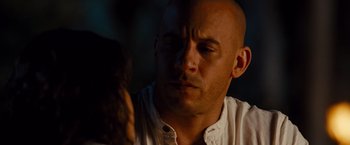 Movie still from “Fast & Furious” (2009), directed by Justin Lin – A bald man with a white shirt is looking down; Close Up shot, Over the shoulder angle
