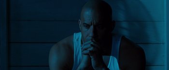 Movie still from “Fast & Furious” (2009), directed by Justin Lin – A bald man with his hands under his chin; Close Up shot, High angle
