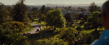 Movie still from “Fast & Furious” (2009), directed by Justin Lin – An aerial view of a cemetery with a bus driving down the road; Extreme Wide shot, High angle