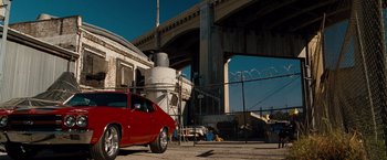 Movie still from “Fast & Furious” (2009), directed by Justin Lin – A red car parked in front of an overpass; Wide shot, Low angle