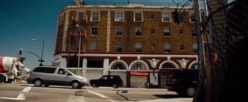 Movie still from “Fast & Furious” (2009), directed by Justin Lin – A building that has a car parked on the side of the street; Extreme Wide shot, Low angle