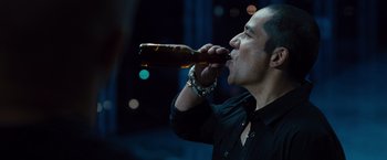 Movie still from “Fast & Furious” (2009), directed by Justin Lin – A man in a black shirt is drinking a beer; Close Up shot, Over the shoulder angle
