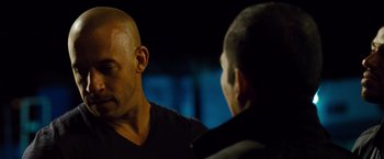 Movie still from “Fast & Furious” (2009), directed by Justin Lin – Two men are looking at one another in the dark; Close Up shot, Over the shoulder angle