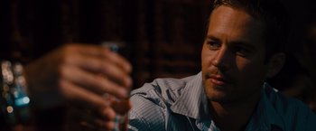Movie still from “Fast & Furious” (2009), directed by Justin Lin – A person holding a glass of wine; Close Up shot, Over the shoulder angle