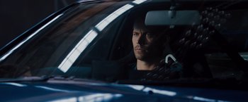 Movie still from “Fast & Furious” (2009), directed by Justin Lin – A man sitting in the driver's seat of a car; Close Up shot, Over the shoulder angle