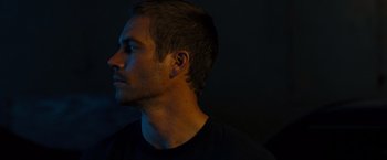 Movie still from “Fast & Furious” (2009), directed by Justin Lin – A person wearing a black t - shirt; Close Up shot, Over the shoulder angle