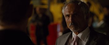 Movie still from “Fast & Furious” (2009), directed by Justin Lin – An older man wearing a suit and pink tie; Close Up shot, Over the shoulder angle