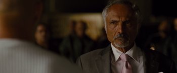 Movie still from “Fast & Furious” (2009), directed by Justin Lin – An older man wearing a suit and pink tie; Close Up shot, Over the shoulder angle
