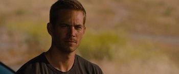 Movie still from “Fast & Furious” (2009), directed by Justin Lin – A person wearing a black t - shirt; Close Up shot, Over the shoulder angle