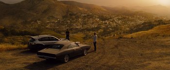 Movie still from “Fast & Furious” (2009), directed by Justin Lin – Two people standing next to a car on a hill; Wide shot, High angle
