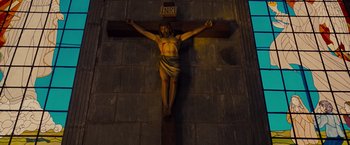Movie still from “Fast & Furious” (2009), directed by Justin Lin – A crucifixion statue of jesus on the cross; Wide shot, Overhead angle
