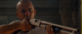 Movie still from “Fast & Furious” (2009), directed by Justin Lin – A bald man holding a gun in his hand; Close Up shot, Over the shoulder angle