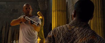 Movie still from “Fast & Furious” (2009), directed by Justin Lin – A man standing next to a statue of a woman; Medium shot, Over the shoulder angle