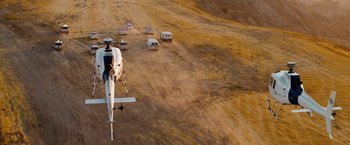 Movie still from “Fast & Furious” (2009), directed by Justin Lin – An aerial view of a group of vehicles on a dirt road; Extreme Wide shot, High angle