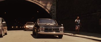 Movie still from “Fast Five” (2011), directed by Justin Lin – An old car is parked on the side of the road; Wide shot, Low angle
