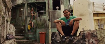 Movie still from “Fast Five” (2011), directed by Justin Lin – A man sitting on the side of a building next to a woman; Wide shot, Low angle