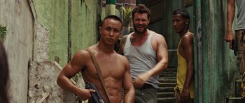Movie still from “Fast Five” (2011), directed by Justin Lin – A man holding a gun standing next to another man; Medium shot, Low angle