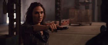 Movie still from “Fast Five” (2011), directed by Justin Lin – A beautiful woman holding a gun while standing in a parking lot; Close Up shot, Over the shoulder angle