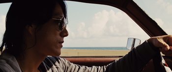 Movie still from “Fast Five” (2011), directed by Justin Lin – A person in a car looking out the window at the beach; Close Up shot, Over the shoulder angle