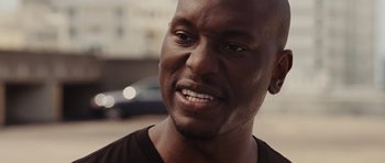 Movie still from “Fast Five” (2011), directed by Justin Lin – A person with a car in the background; Close Up shot, Over the shoulder angle