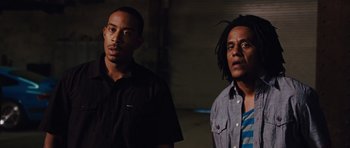 Movie still from “Fast Five” (2011), directed by Justin Lin – A couple of men standing next to each other; Medium shot, Low angle