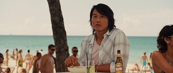 Movie still from “Fast Five” (2011), directed by Justin Lin – A man sitting at a table with a bowl of food; Medium shot, Over the shoulder angle