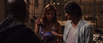 Movie still from “Fast Five” (2011), directed by Justin Lin – A woman looking at a cell phone while a man looks on; Medium shot, Over the shoulder angle