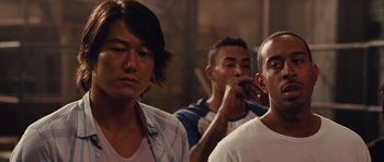 Movie still from “Fast Five” (2011), directed by Justin Lin – A group of men standing next to each other; Close Up shot, Over the shoulder angle