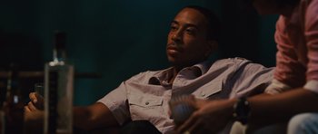 Movie still from “Fast Five” (2011), directed by Justin Lin – A man sitting in a chair holding a glass; Close Up shot, Low angle